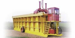 A modern module builder with cab for operator comfort and hydraulic drive system. A tractor provides PTO power to drive the hydraulic pump and drawbar power to move the builder. (Photo courtesy of KBH, Inc.)
